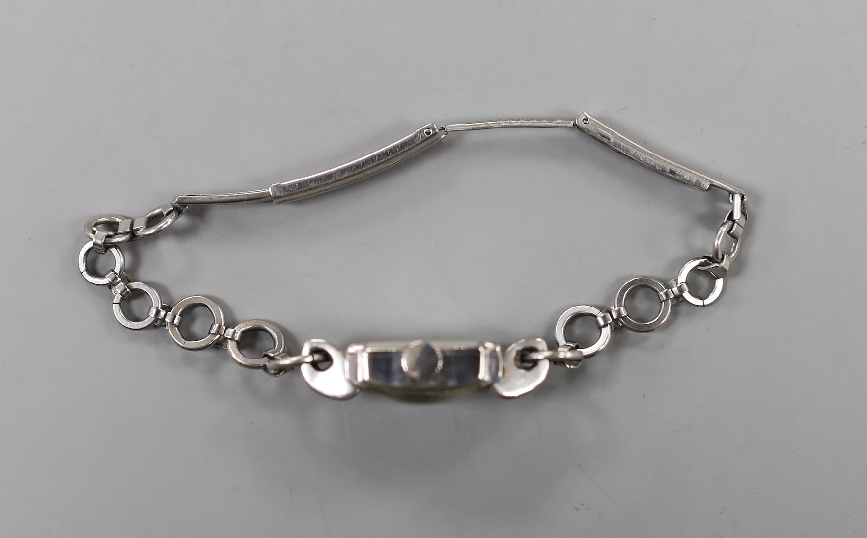 A lady's stainless steel Longines manual wind wrist watch, with fluted lugs, on associated steel chain link bracelet.